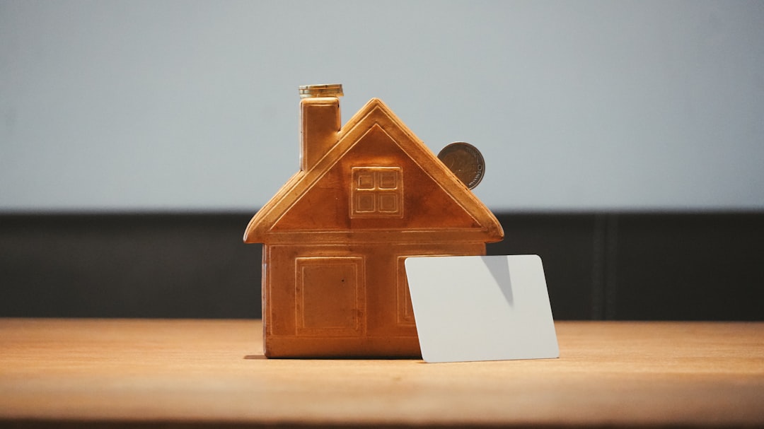 a-small-house-bank-with-a-coin-and-blank-card-duwzp3jzvc4